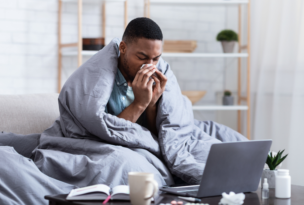 man with runny nose and nasal congestion blowing into a tissue